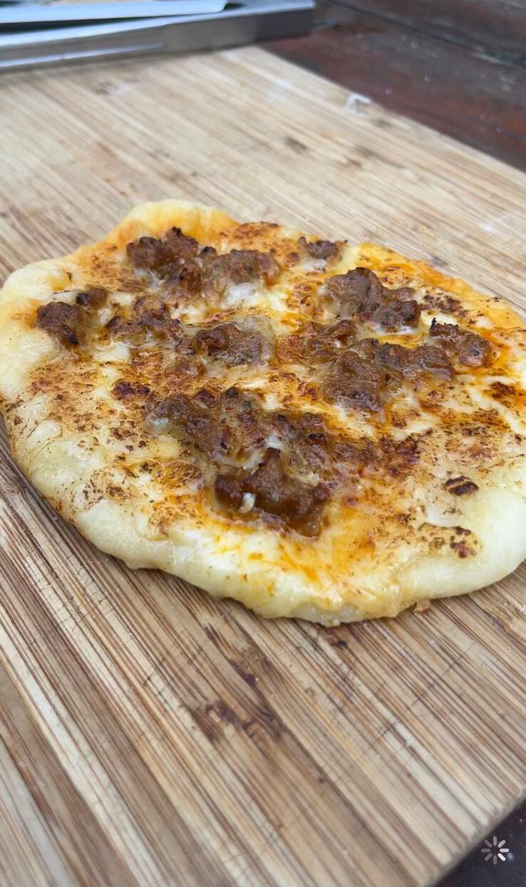 Pizzeta op de BBQ: Gegrilde pizzeta met mozzarella, Parmezaanse kaas en gegrilde toppings op de BBQ.
